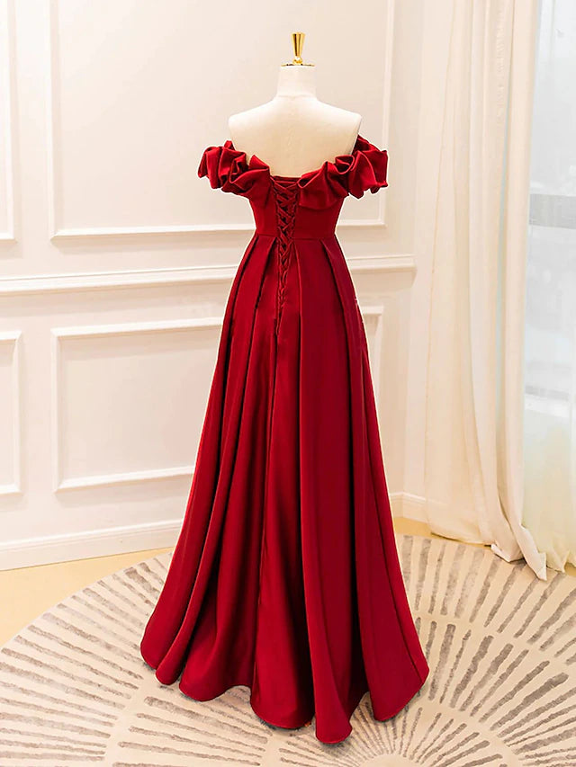 Back view of the strappy V-neck gown, showing the graceful pleated skirt.