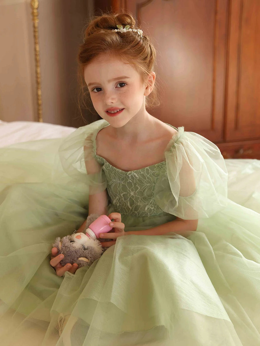 Close-up of the V-neckline and delicate puff sleeves on the flower girl dress.