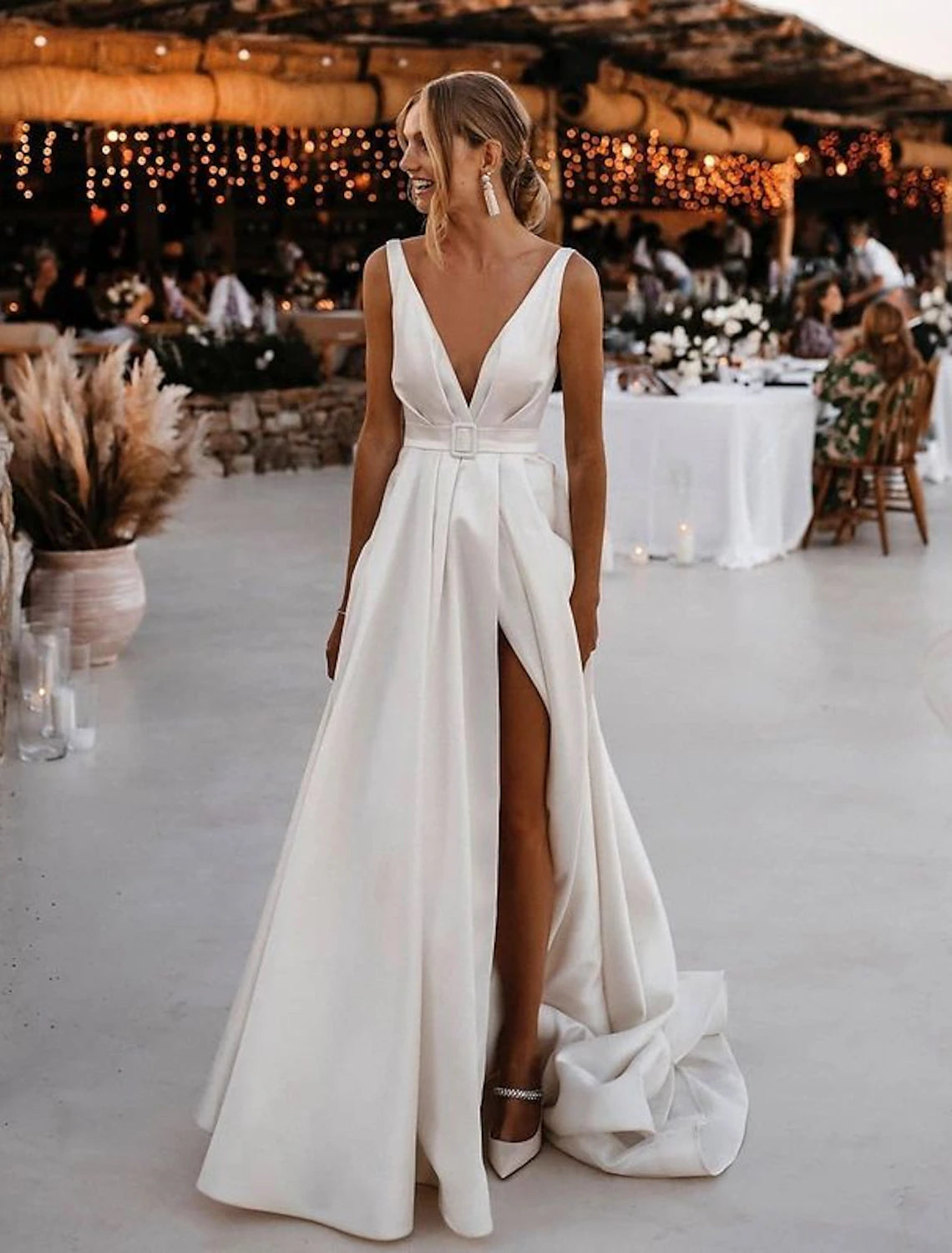 Model posing in the sleeveless satin bridal gown, showcasing its casual elegance.