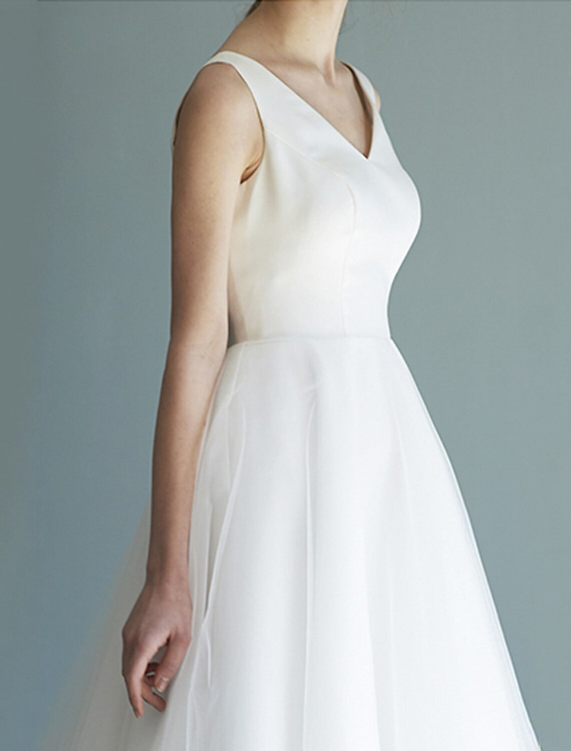 Side view of the white A-line V-neck satin tea length wedding dress.