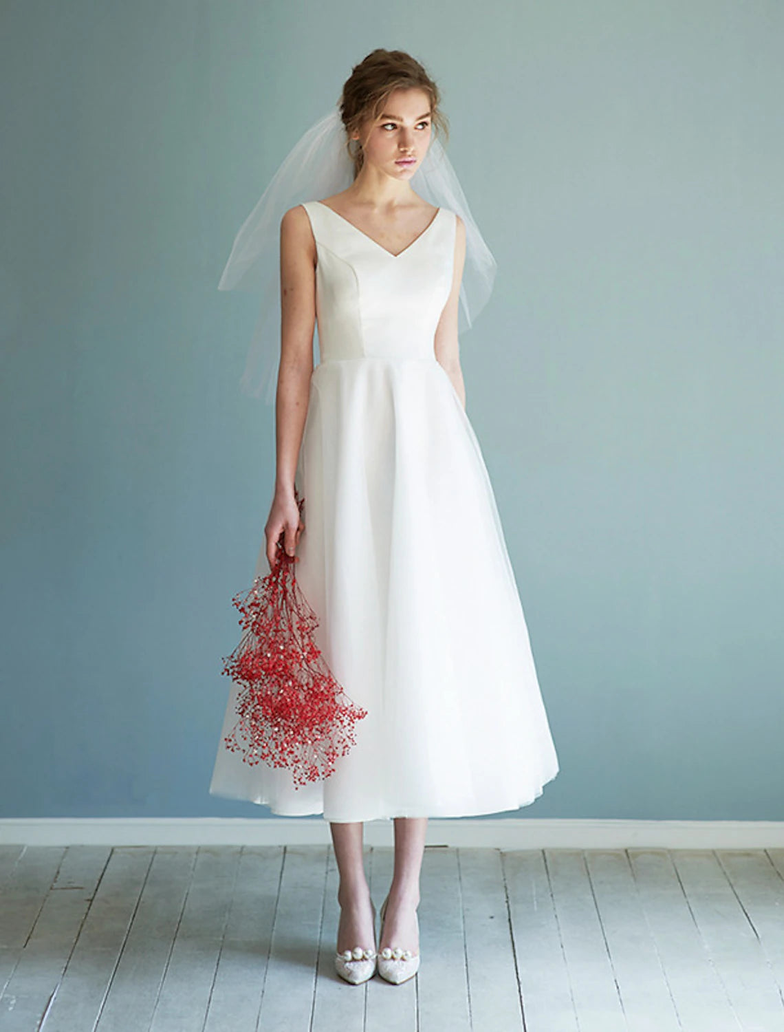 Close-up of the satin fabric on the white A-line V-neck tea length dress.