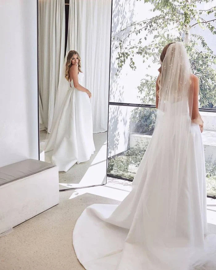 Full view of a graceful A-Line V-Neck satin bridal gown.
