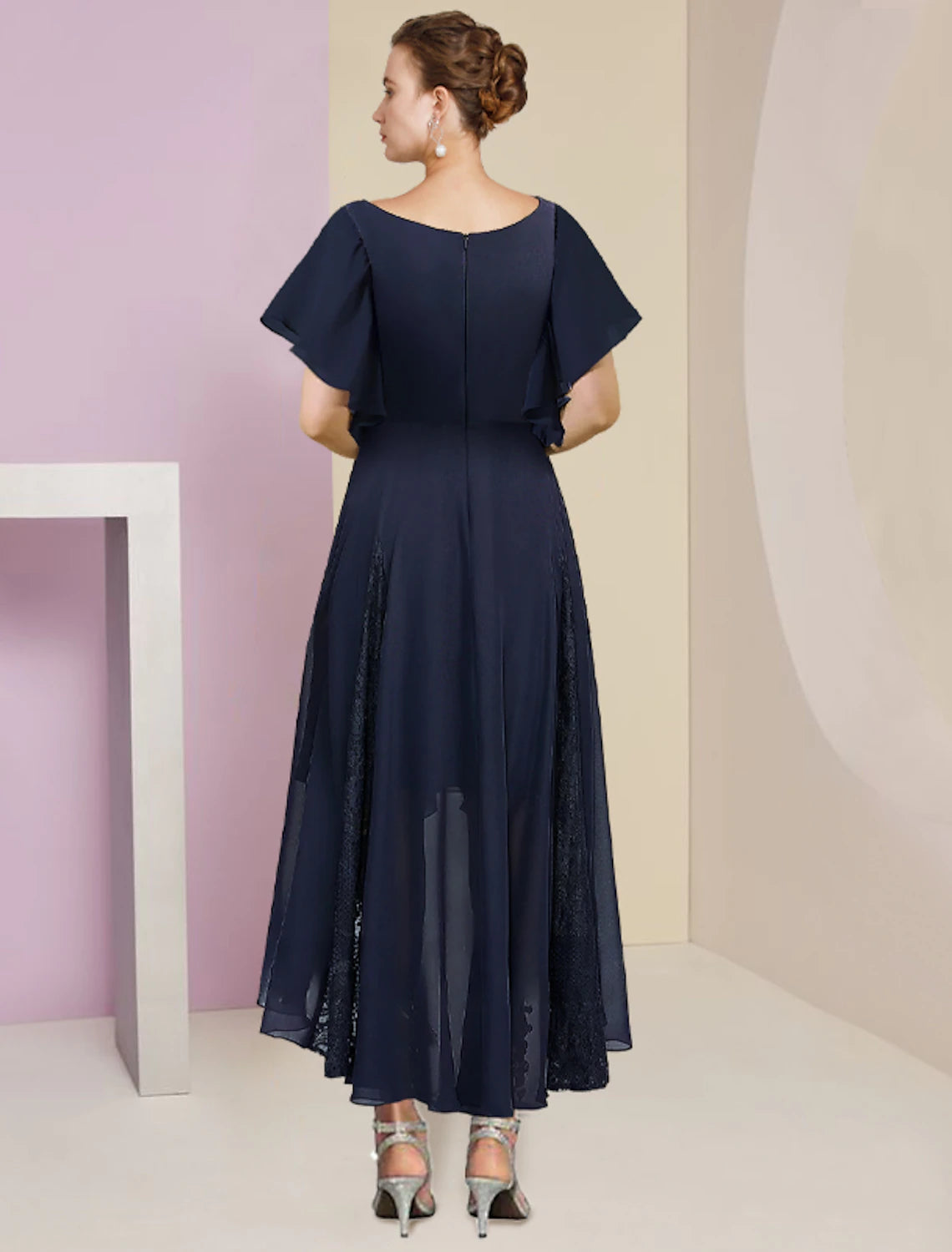 Back view of the elegant wedding guest gown with pleats.
