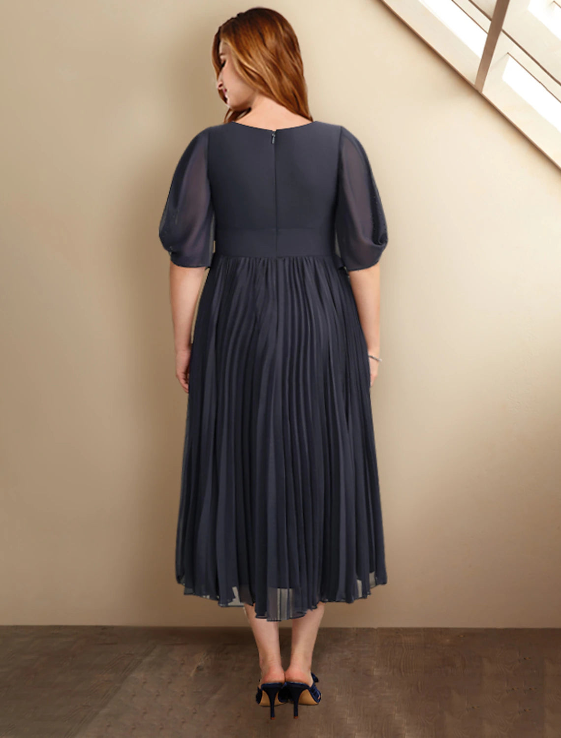 Back view of the elegant tea length chiffon dress with pleats.