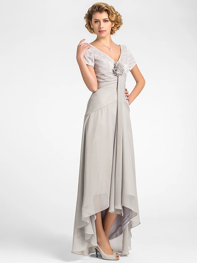 Woman wearing an elegant A-line floral chiffon and lace mother of the bride dress with a V-neck and high-low hem.