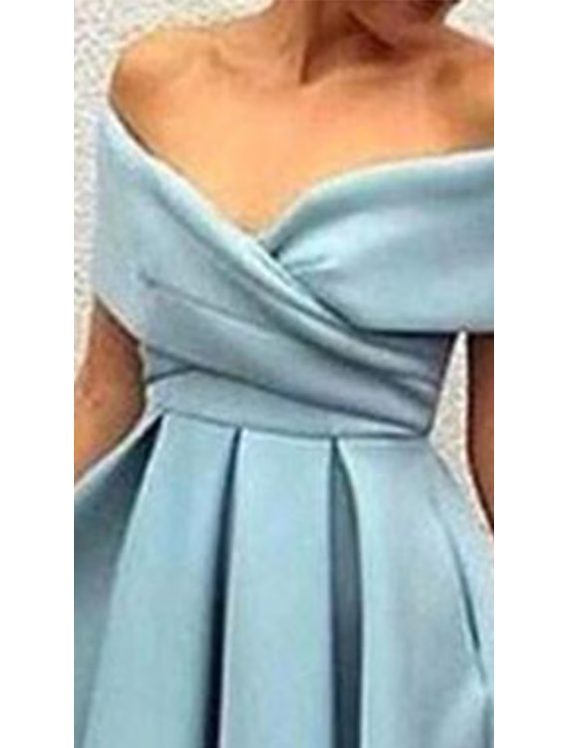 Back view of an A-line V-neck short sleeve dress showing V-back and pleats.