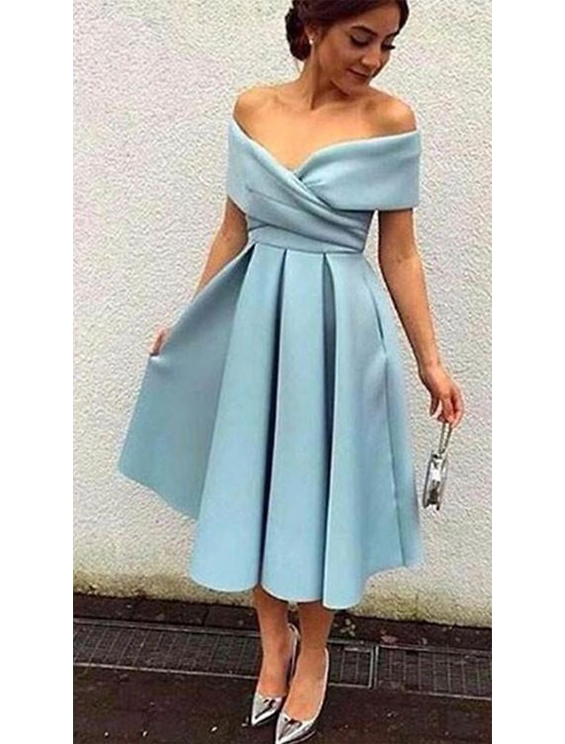 Side view of a woman in an A-line tea length dress with short sleeves.