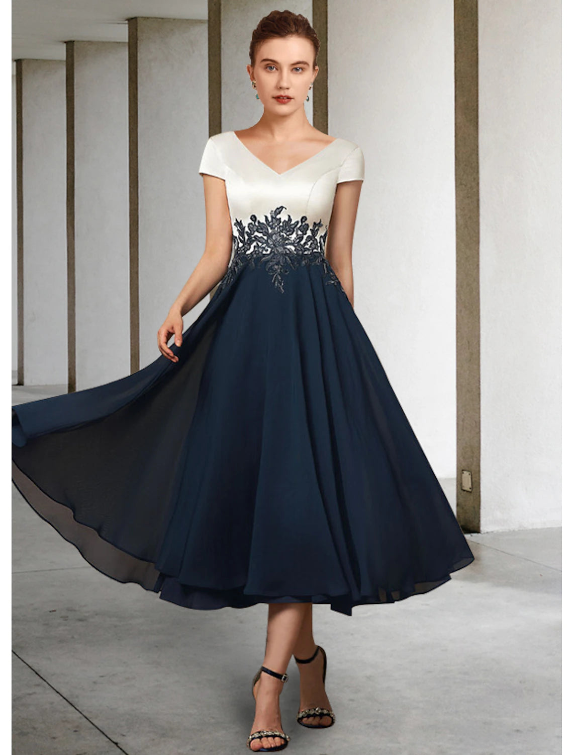 Elegant A-Line V-neck tea length Mother of the Bride dress with short sleeves, pleats, and lace appliques.