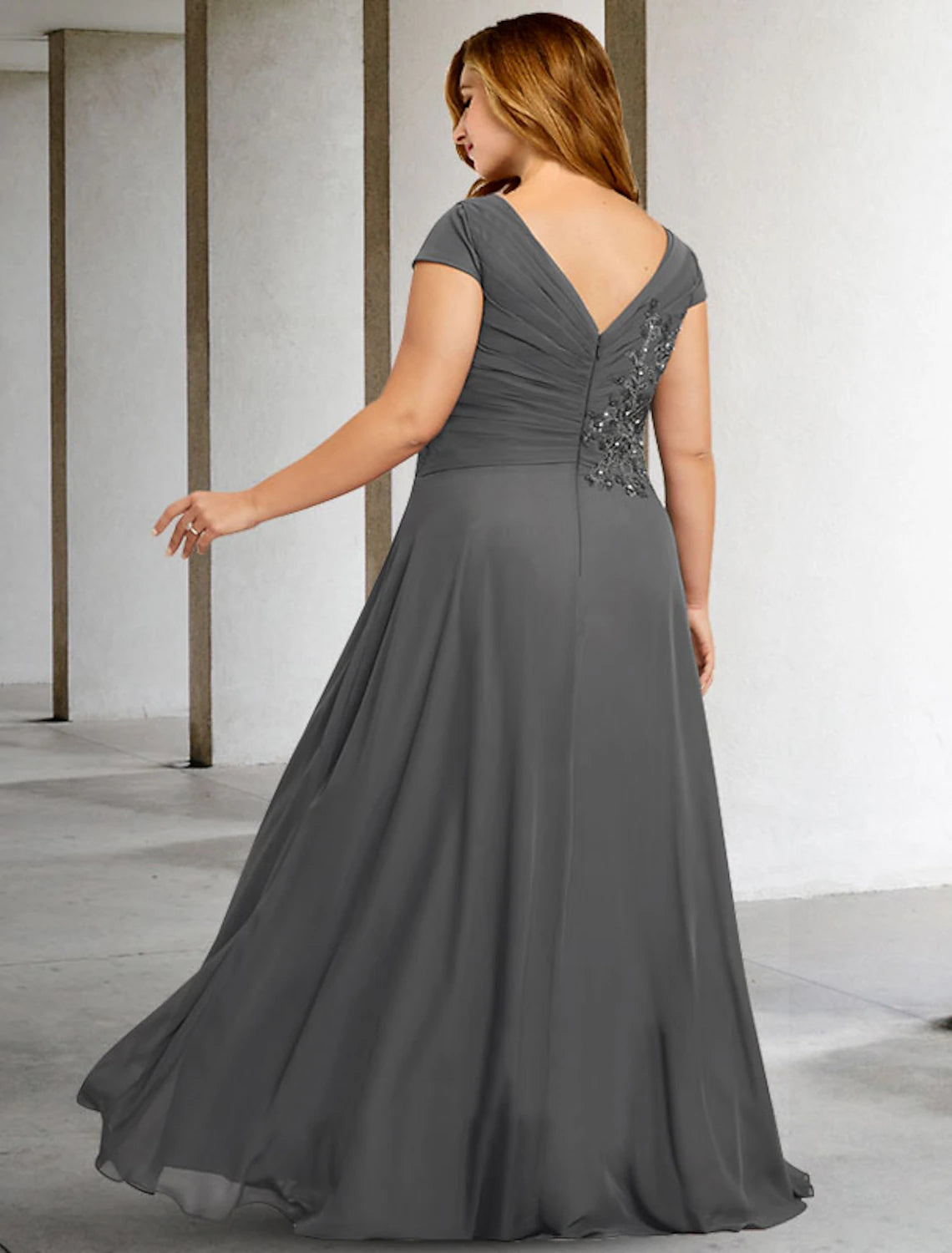 Side view of the elegant chiffon gown with pleats and sequin appliques.
