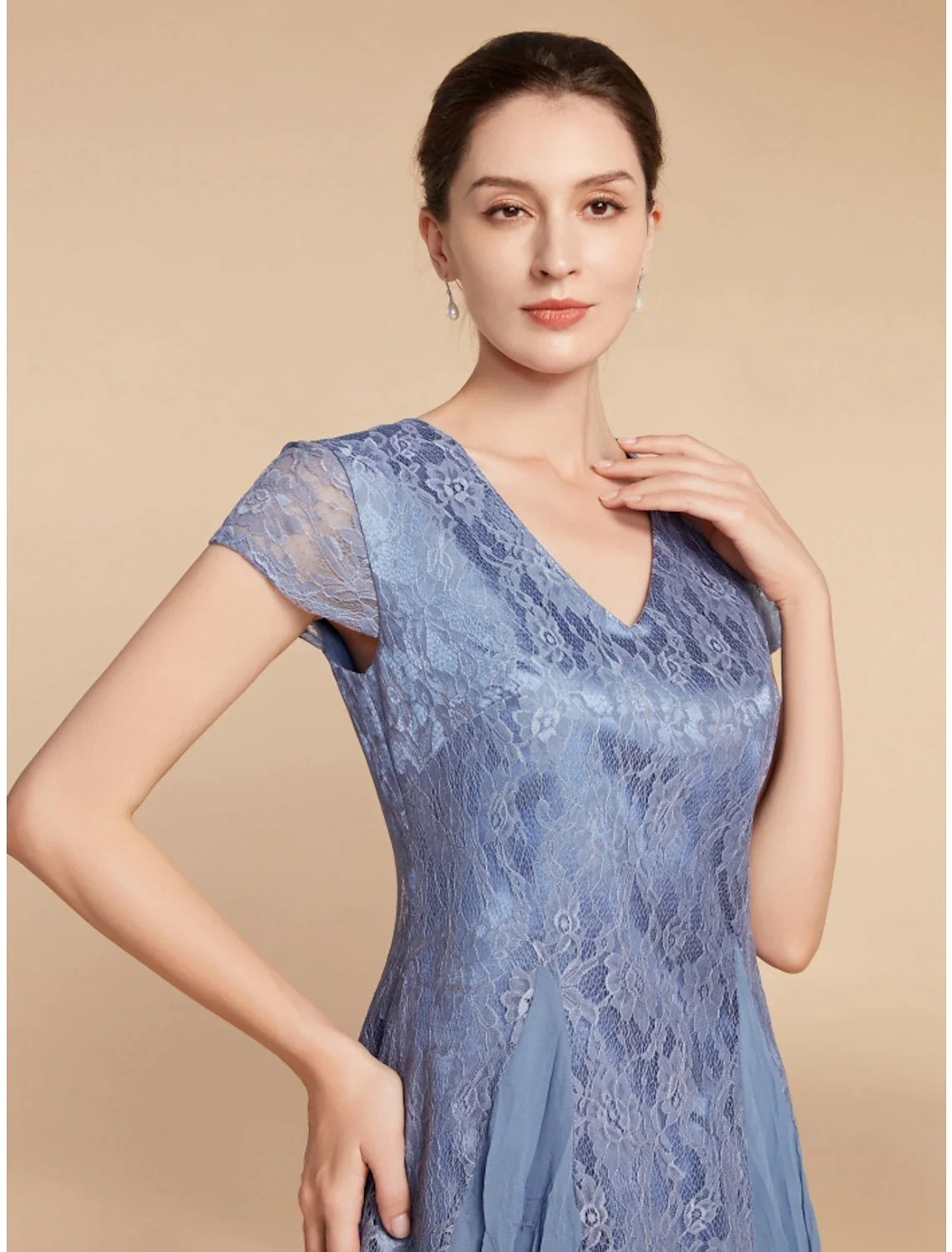 Close-up of the lace and ruched detailing on the V-neck dress.
