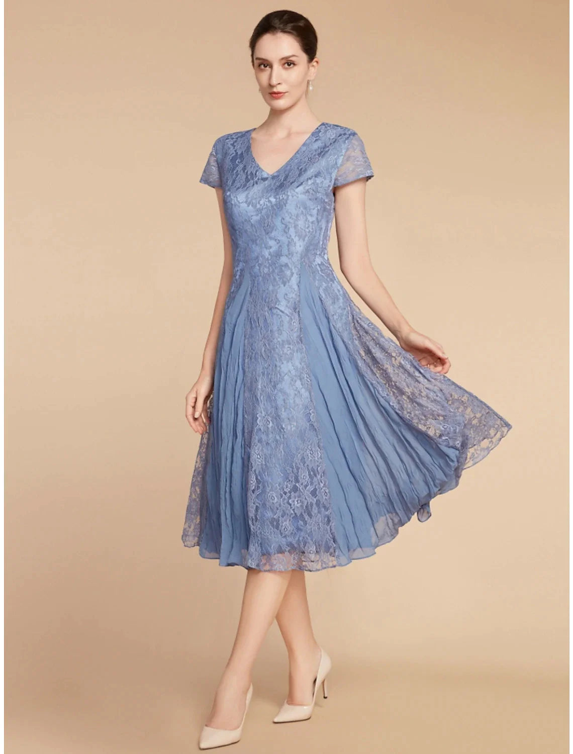 Model wearing the elegant knee-length dress, suitable for wedding guests.