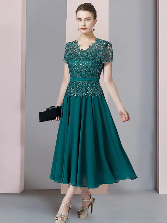 Close-up of the V-neckline, short sleeve, and sequin appliques on the dress.