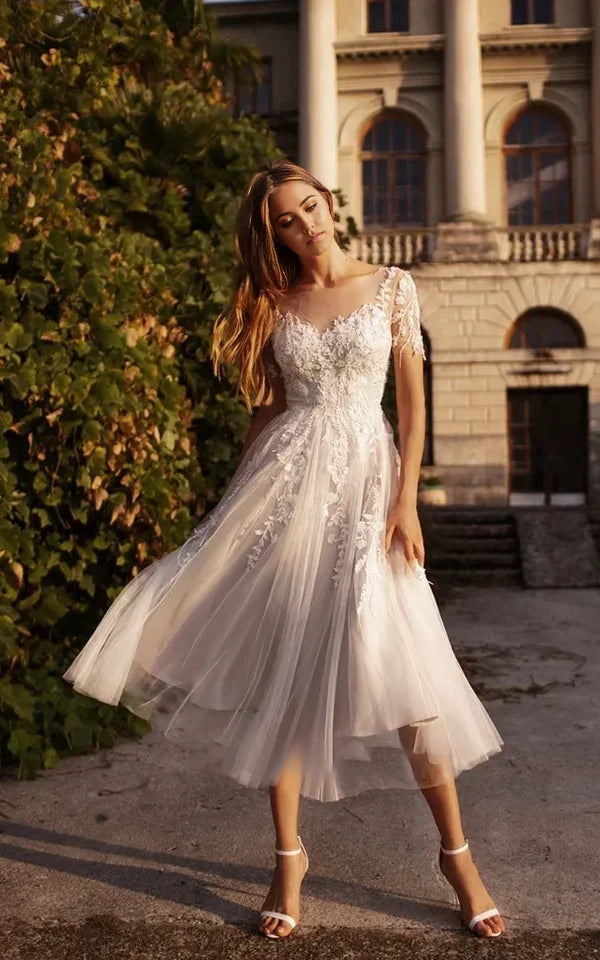 Elegant A-line V-neck tea length wedding dress with short sleeves.