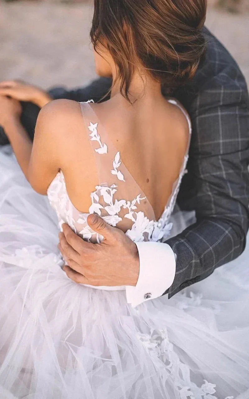 Boho romantic A-line wedding gown featuring a V-neck, lace, and tulle.