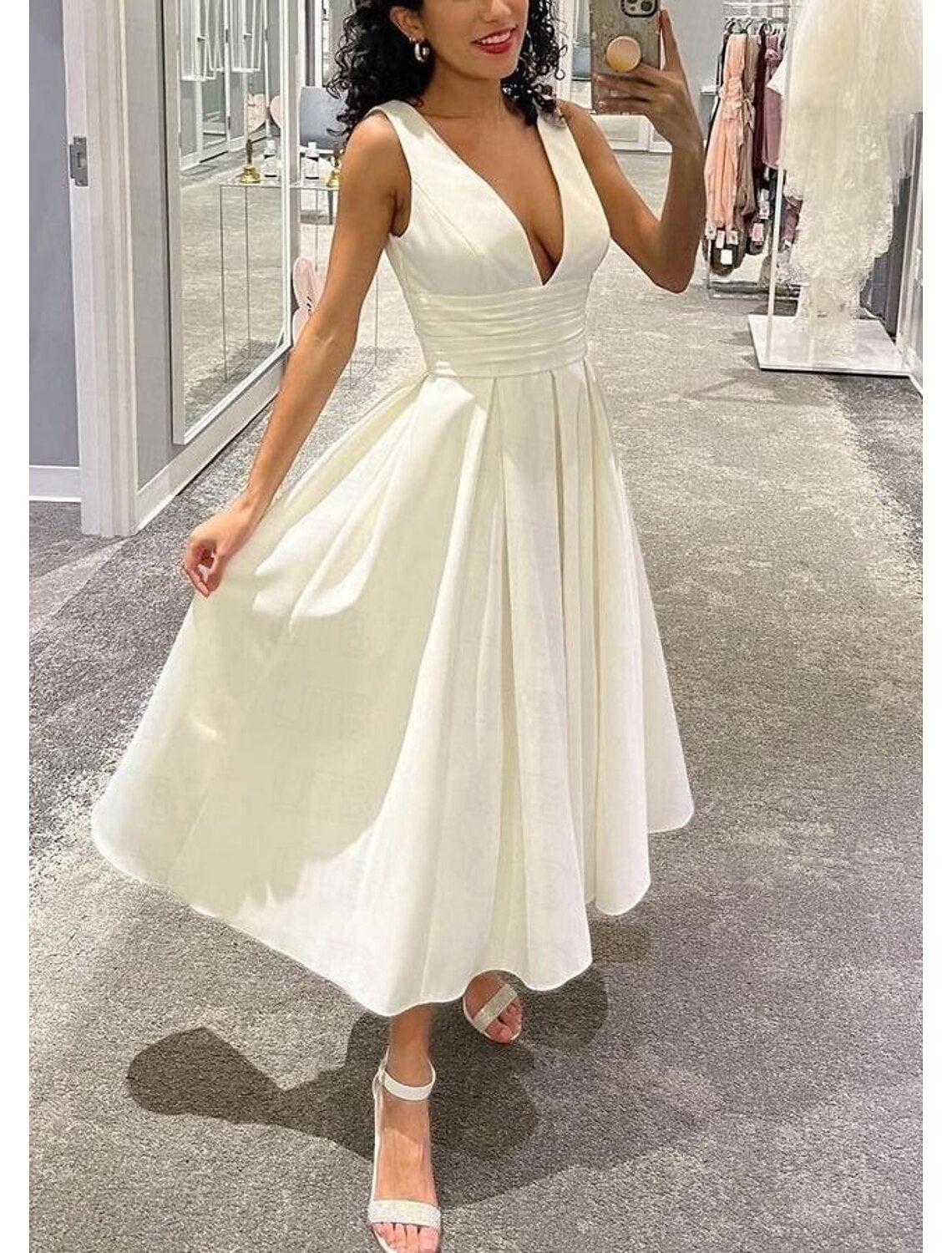 Back view of the white satin tea length wedding dress, showcasing its graceful drape.