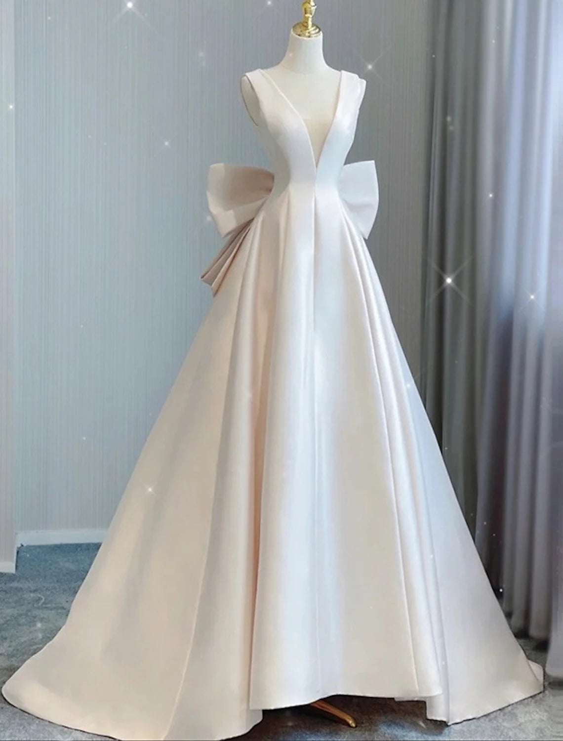 A-Line V-neck satin wedding dress with a court train and bow details.