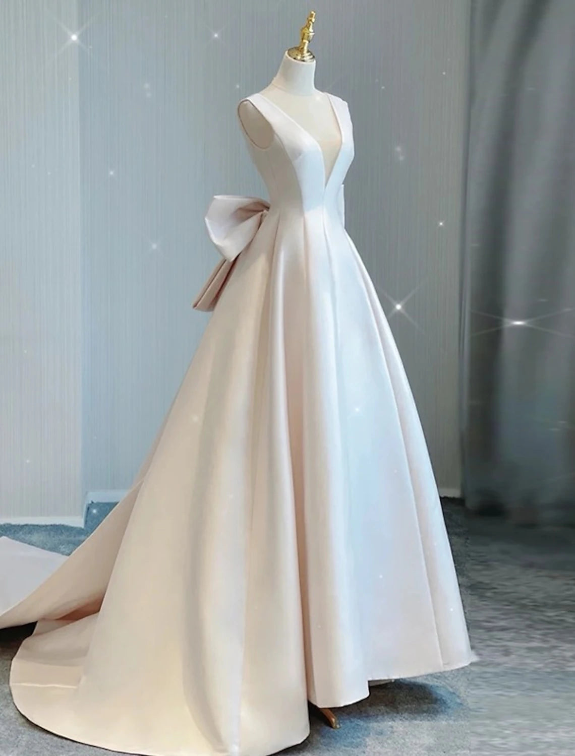 Side profile of an elegant A-line wedding dress, highlighting the V-neck and satin fabric.