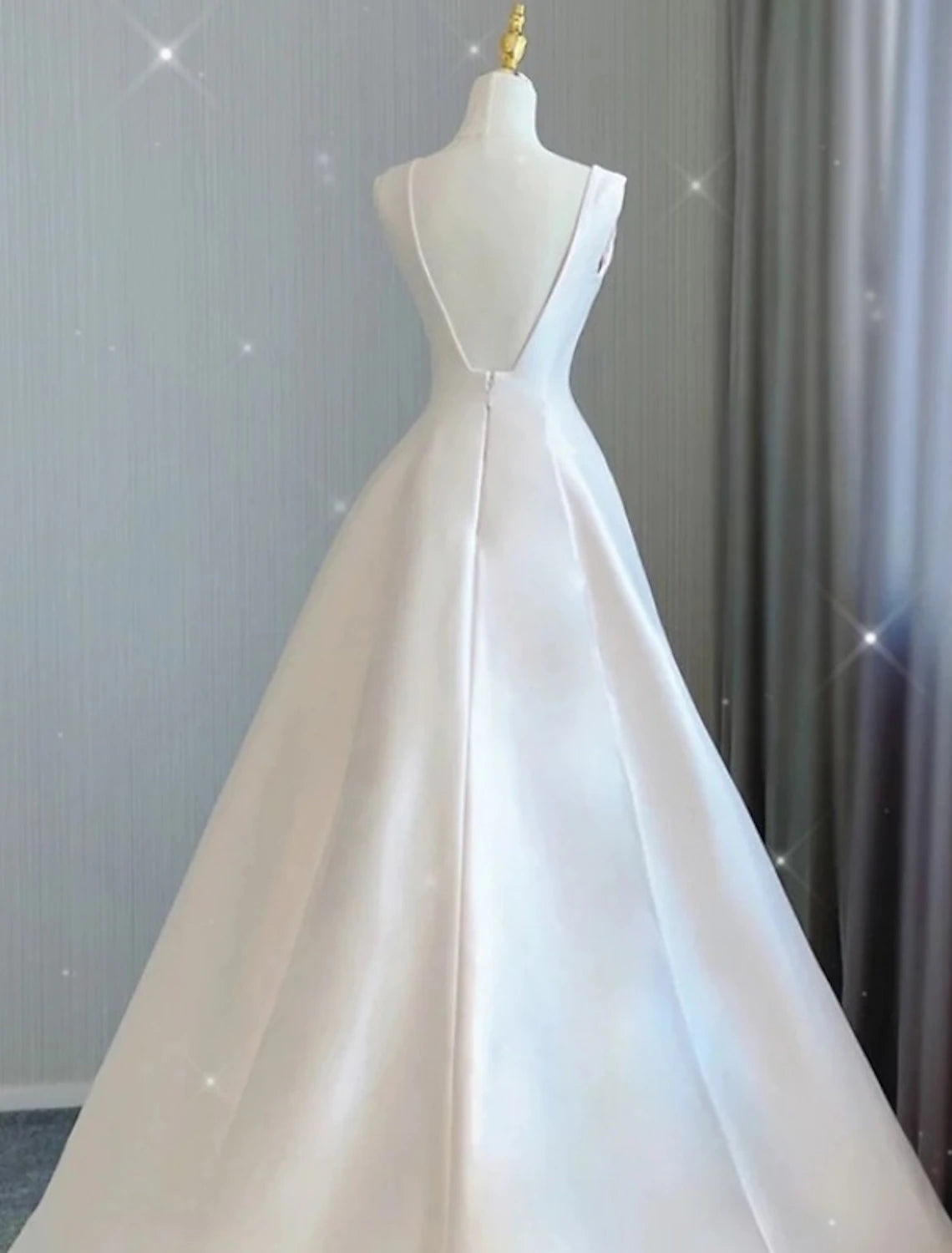 Close-up of the V-neckline and bodice of the satin wedding dress.