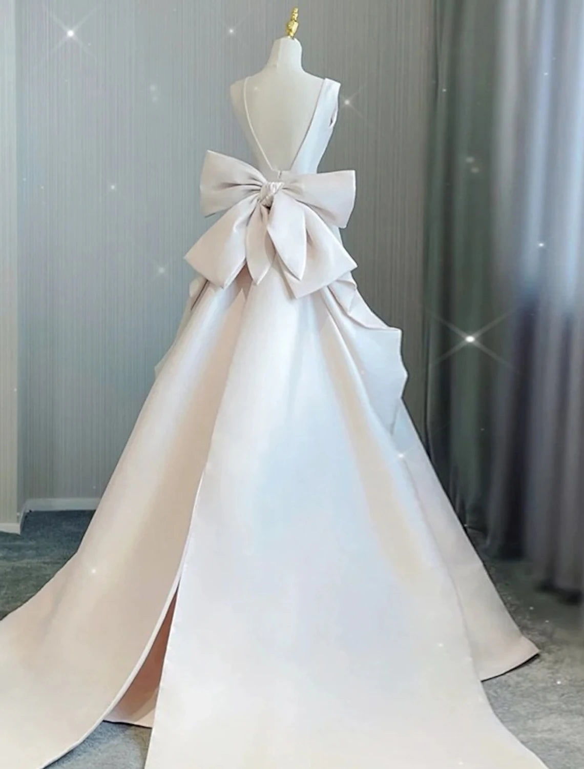 Full length view of a bride wearing the sleeveless A-line satin wedding gown.