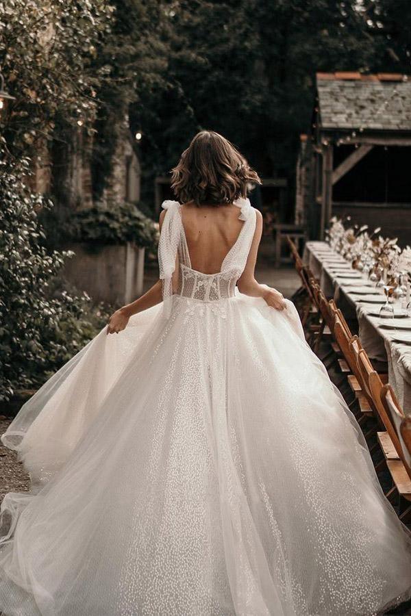 Back view of an ivory A-line wedding gown featuring a sweep train.