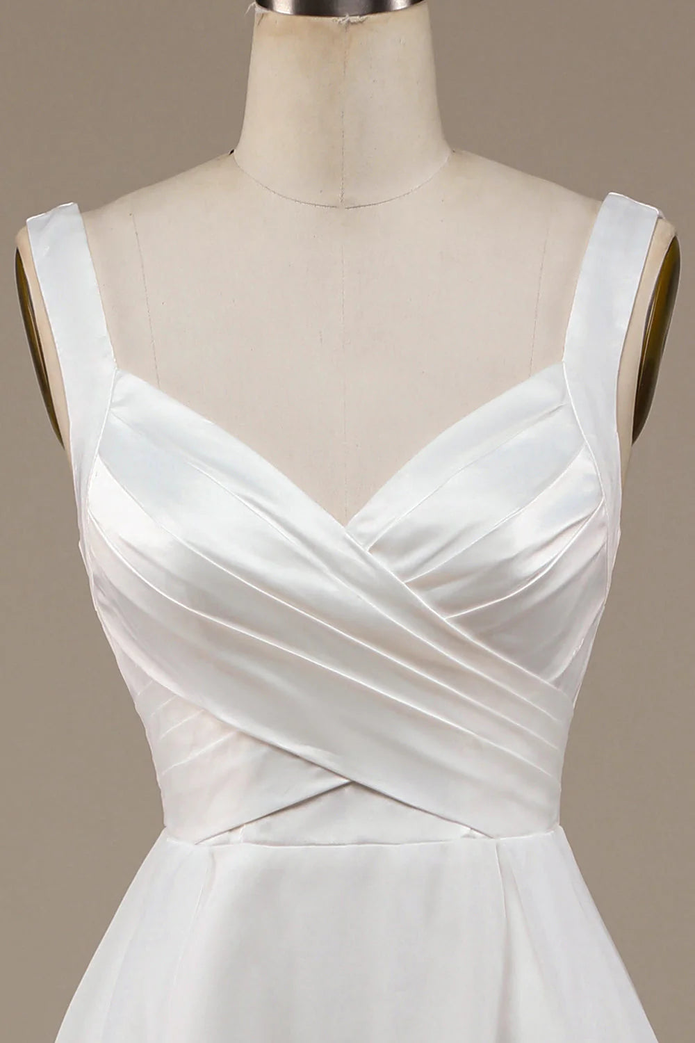 Close-up of the V-neckline and fabric detail of the ivory wedding dress.