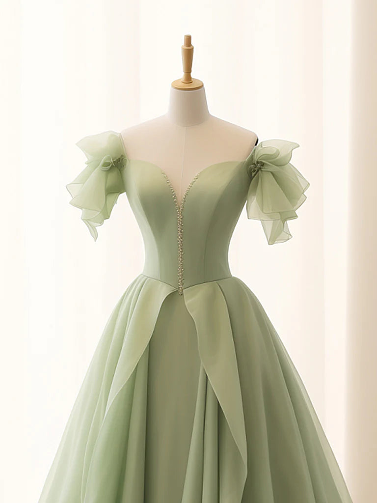 Full-length view of a green A-line tulle gown.