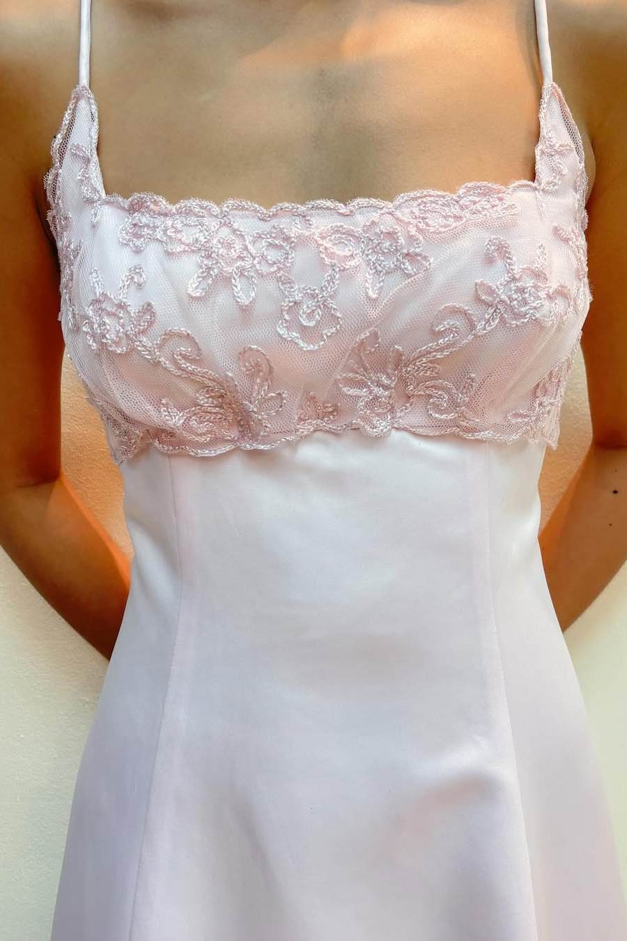 Close-up of appliques on the empire waist of a pink satin dress.