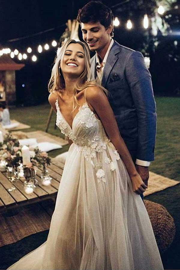Elegant A-line V-neck spaghetti strap beach wedding dress on a model.
