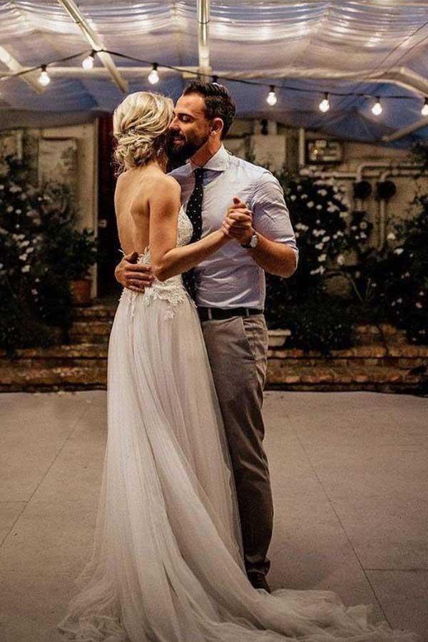 Side view of a backless A-line V-neck wedding dress with spaghetti straps.