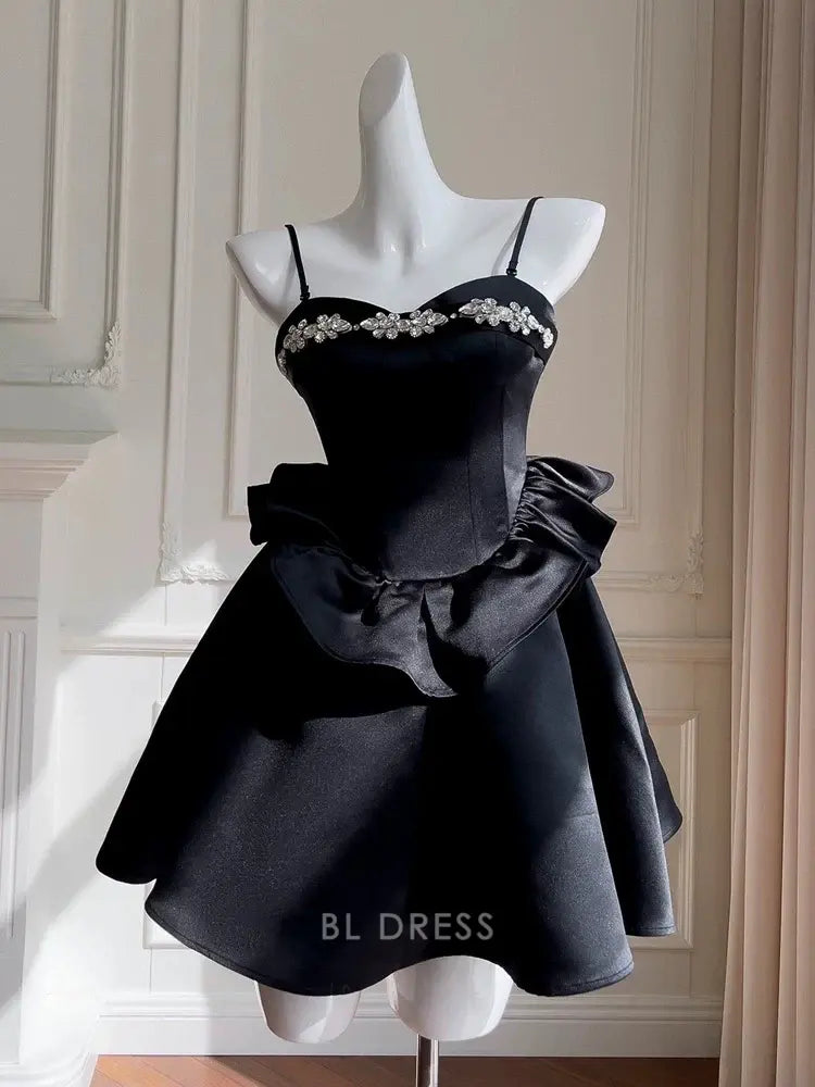 Model wearing an elegant black A-line satin dress with spaghetti straps and beaded embellishments.