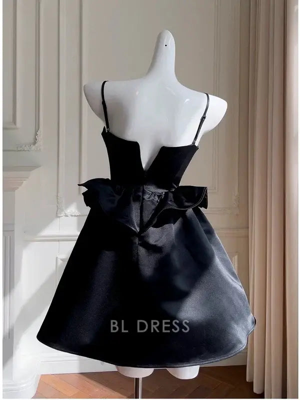 Close-up of the black satin dress, highlighting the V-neckline and intricate beadwork.