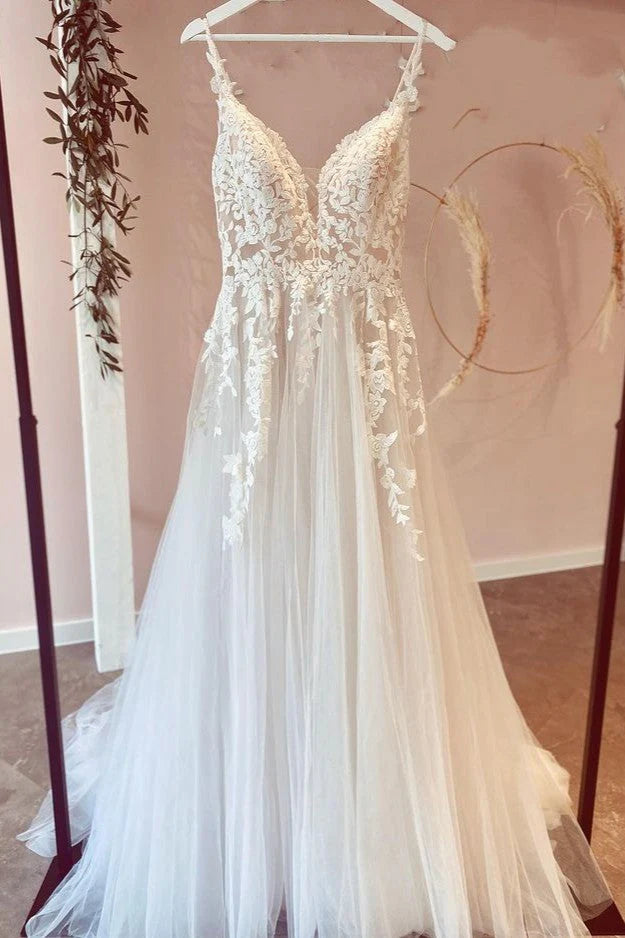 Elegant A-line V-neck wedding dress with delicate lace appliques and spaghetti straps.