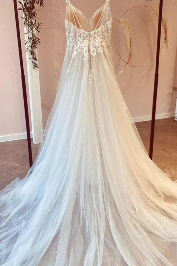 Detailed view of intricate lace appliques on a white A-line wedding gown.
