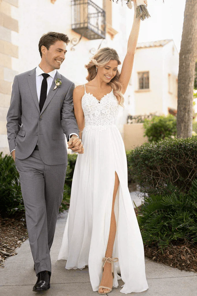 Elegant A-line wedding dress with spaghetti straps, V-neck, lace details, and a flowing chiffon split.