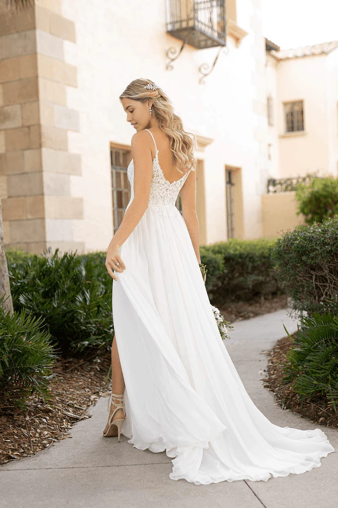 Back view of a long A-line wedding dress featuring spaghetti straps and a graceful train.
