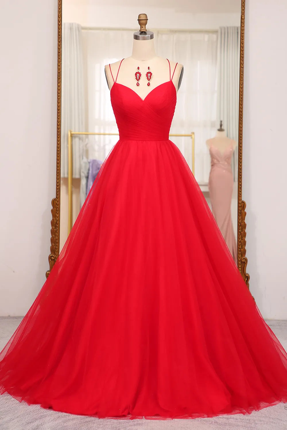 Model wearing an A-line V-neck spaghetti strap long prom dress with criss-cross back.
