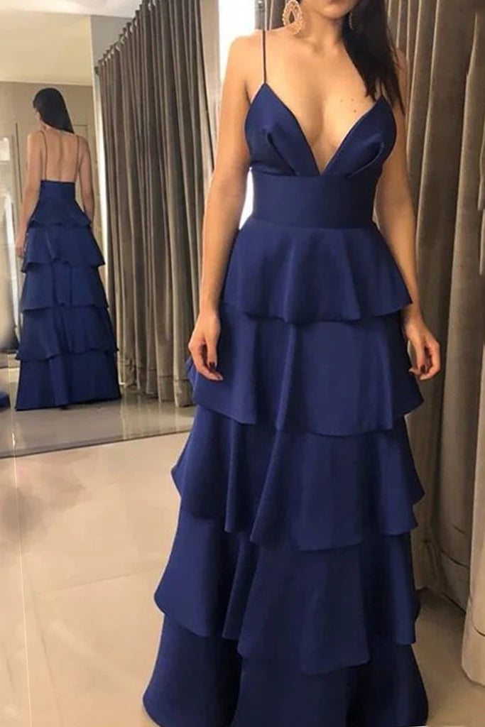 Woman posing in a V-neck spaghetti strap long prom dress.