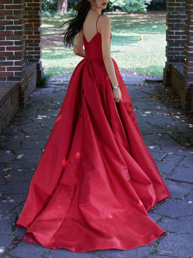 Back view of a long satin prom dress with delicate spaghetti straps.