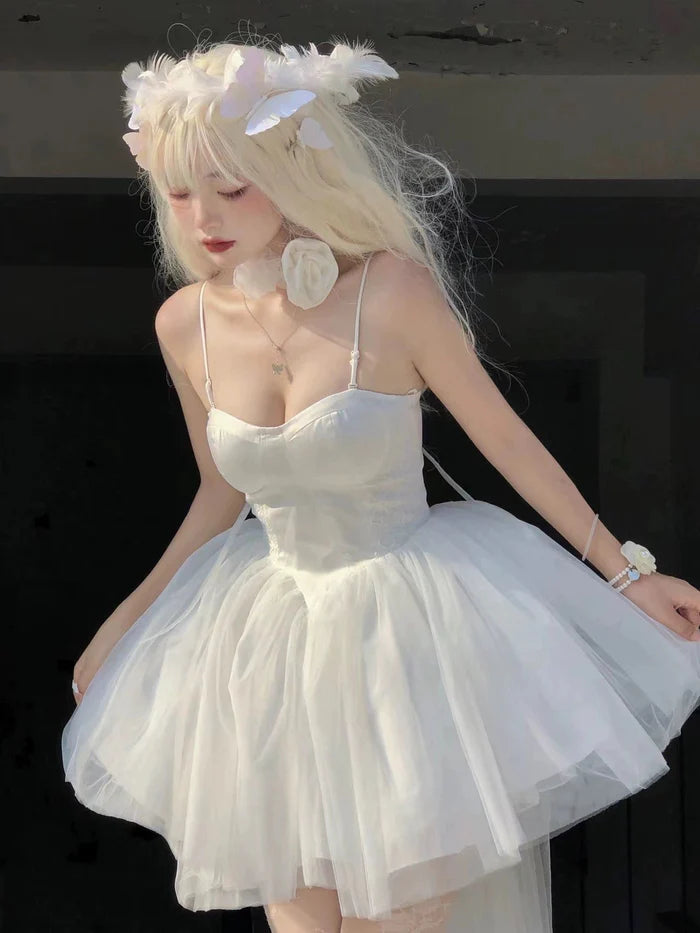 Close-up of the V-neckline and spaghetti straps on the white dress.