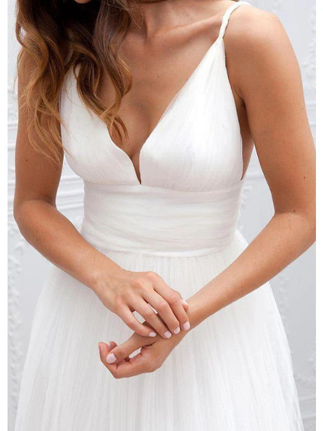 Side view of long wedding dress with delicate spaghetti straps.
