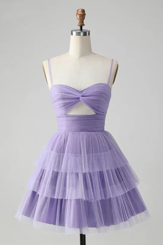 Model wearing an A-line tiered short homecoming dress with spaghetti straps.