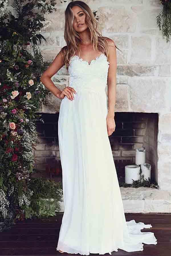 Elegant A-line wedding dress with spaghetti straps and delicate lace appliques.