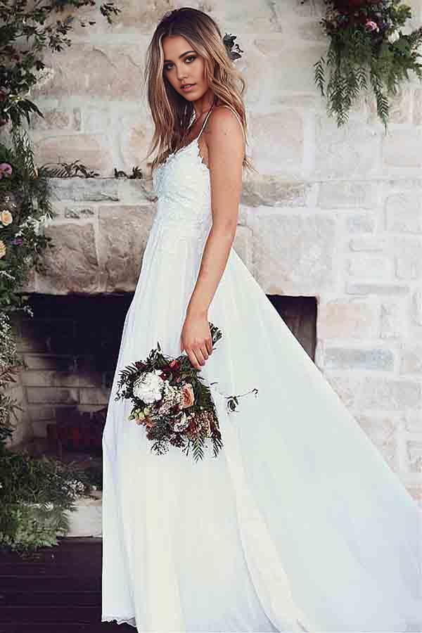 Full view of a bride wearing an A-line spaghetti strap wedding dress.