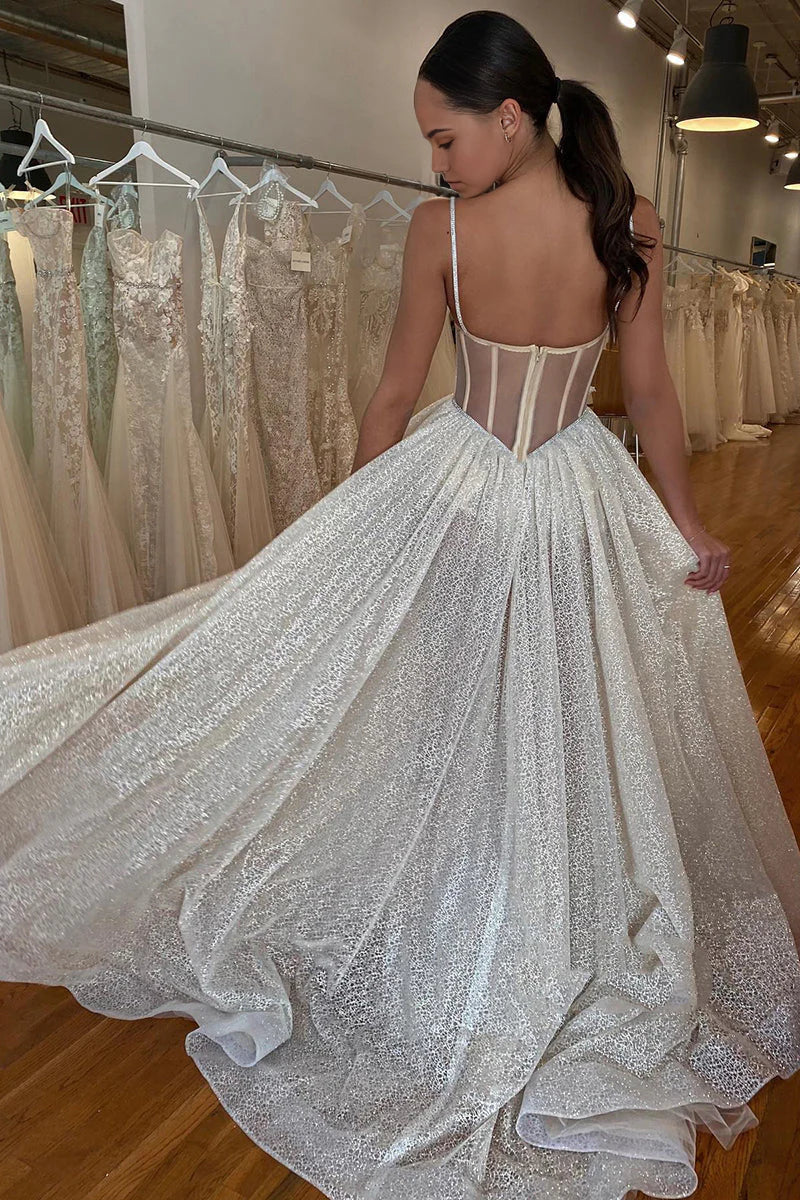 Close-up of the wedding dress bodice with intricate lace appliques and shimmering fabric.