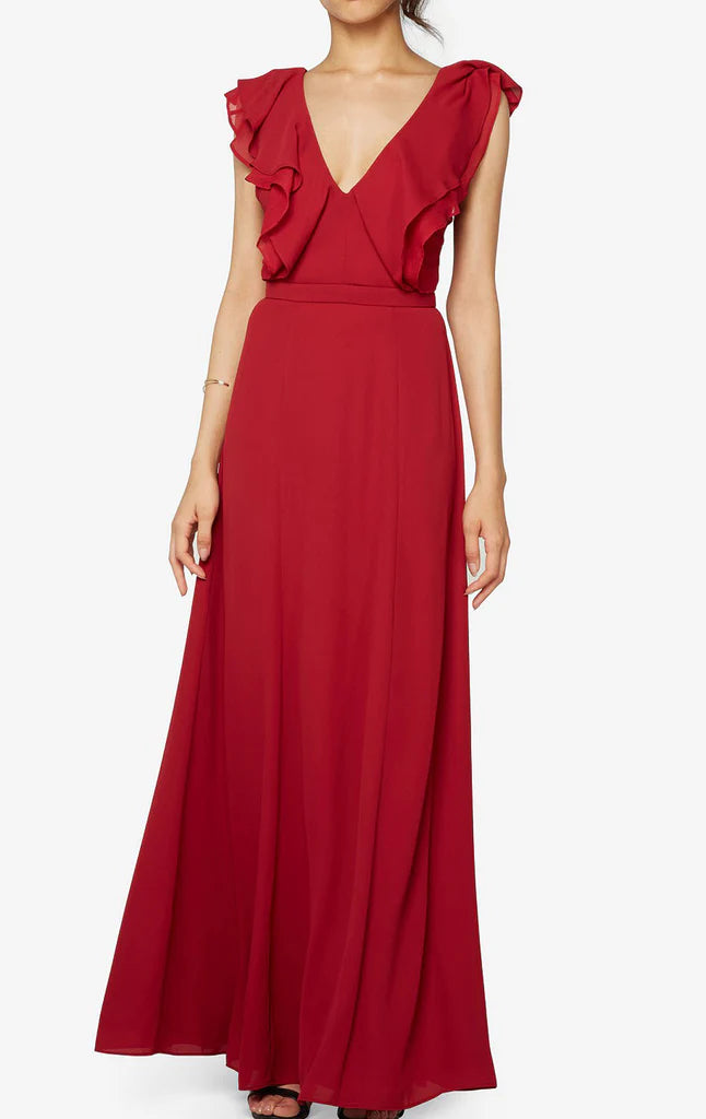 Model in an elegant V-neck chiffon bridesmaid dress with ruffled details and spaghetti straps.