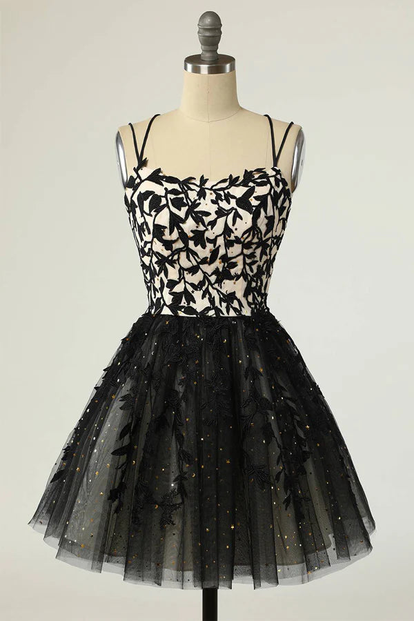 Model wearing a black sequin A-line homecoming dress with appliques and V-neck straps.