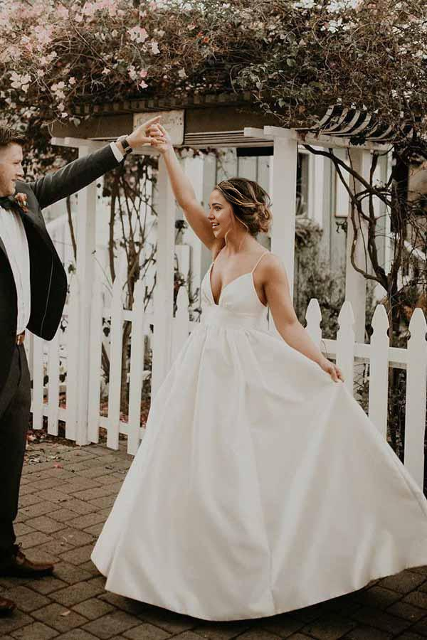 Full view of the ivory A-line wedding dress with V-neck and delicate straps.