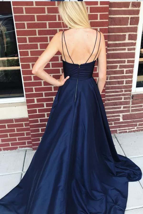 Full view of navy blue satin long prom dress featuring straps and side split.