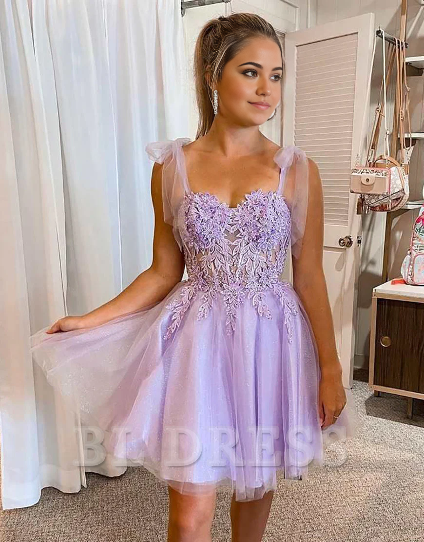 Back view of A-line short dress featuring tie straps and appliques.