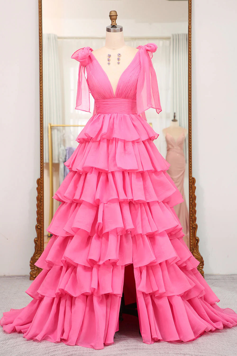 Woman wearing an elegant A-line V-neck tiered long prom dress with a high slit, posing gracefully.